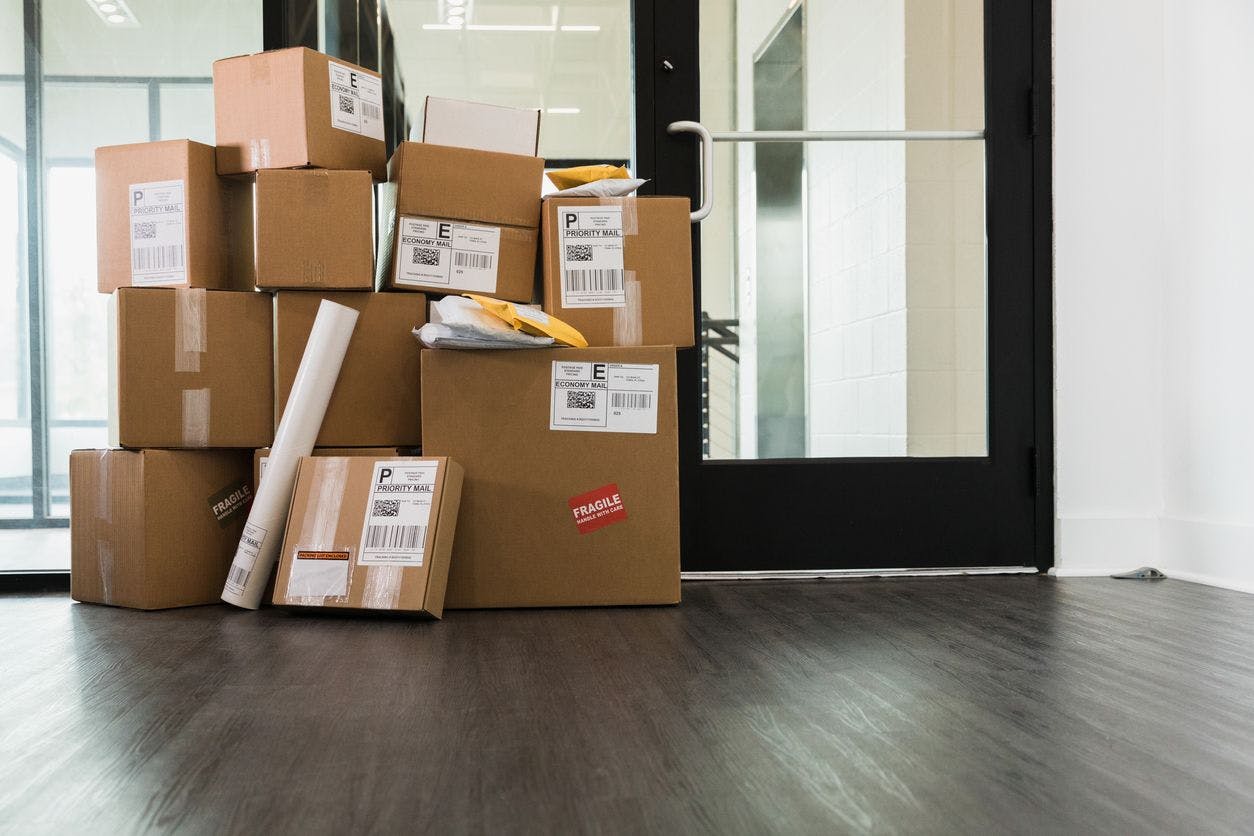 Large stack of delivered packages in office stock photo